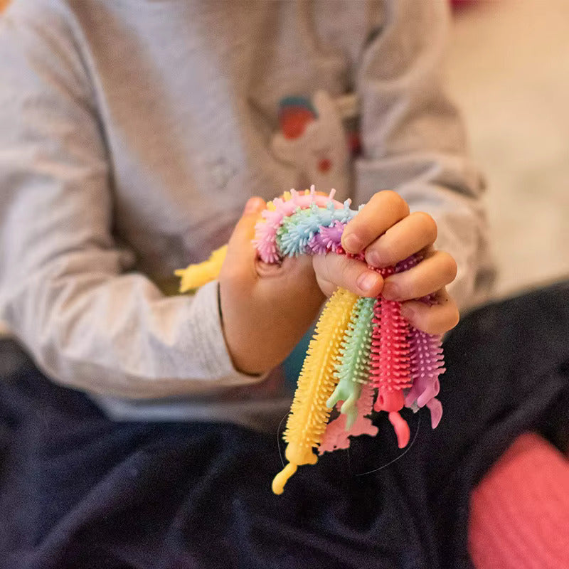 girl playing with sensory stretchy strings from AskSAMIE