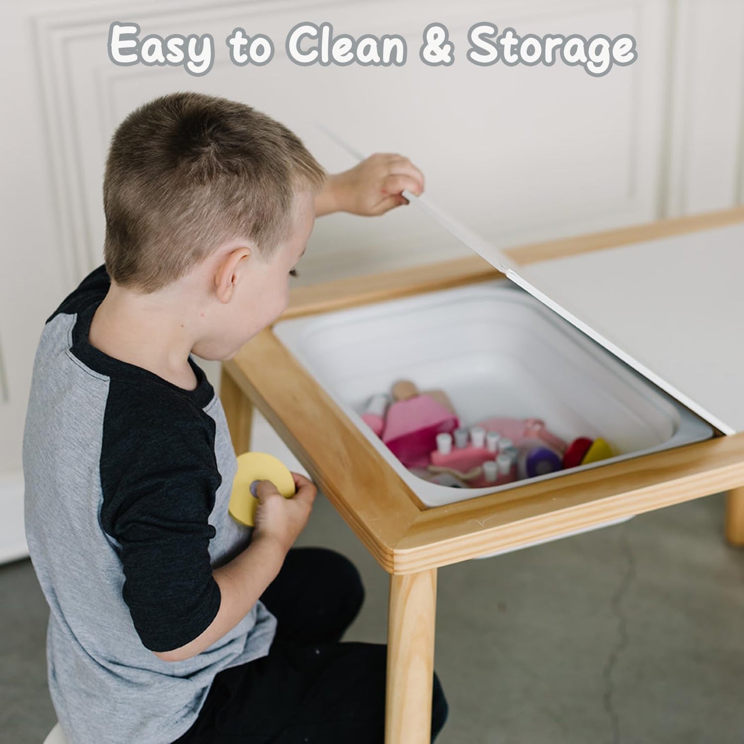 Child cleaning up toys with Sensory Table storage space from AskSAMIE