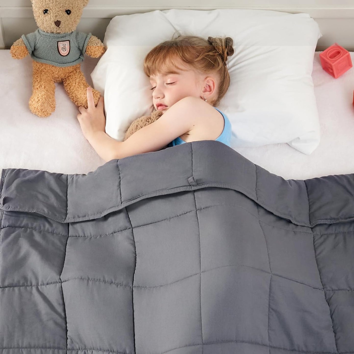 child sleeping in bed with Weighted Blanket in use from AskSAMIE